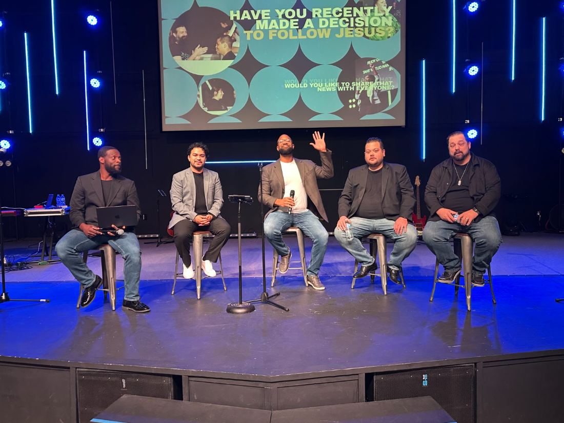 Five men seated on stage for a men's leadership panel